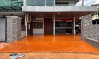 Freshly sealed orange concrete driveway by Hugo's Concrete, showcasing expert concrete services in Fort Collins.