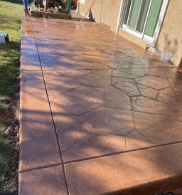 Custom-designed colored concrete patio in a Greeley, CO, backyard, featuring a decorative and durable finish