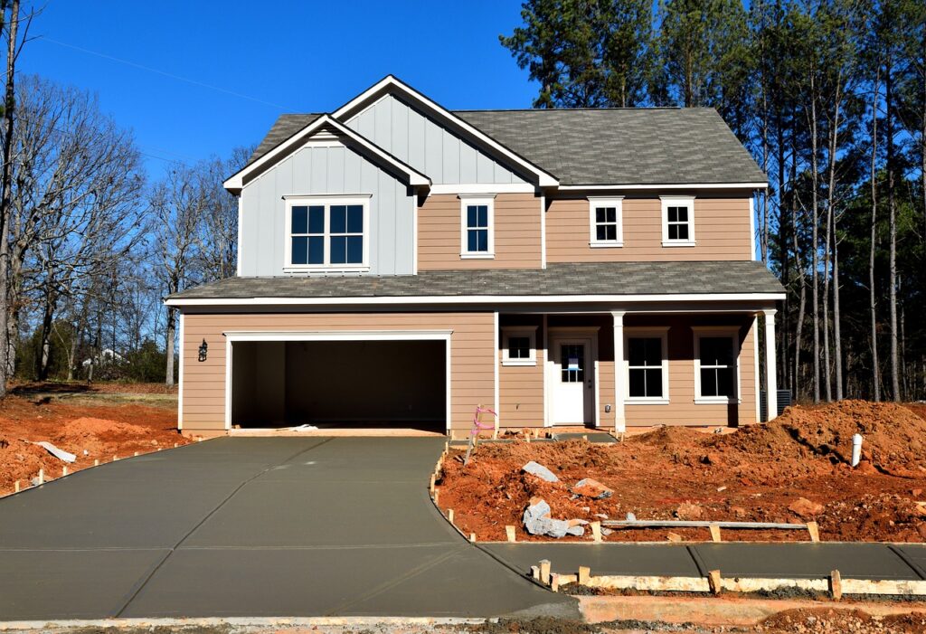 Newly constructed home with freshly poured concrete driveway in Wellington, highlighting commercial concrete services for residential projects.