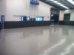 Durable epoxy flooring installation at Loveland Colorado auto shop by Hugo's Concrete, featuring heavy-duty commercial surface for automotive service garage