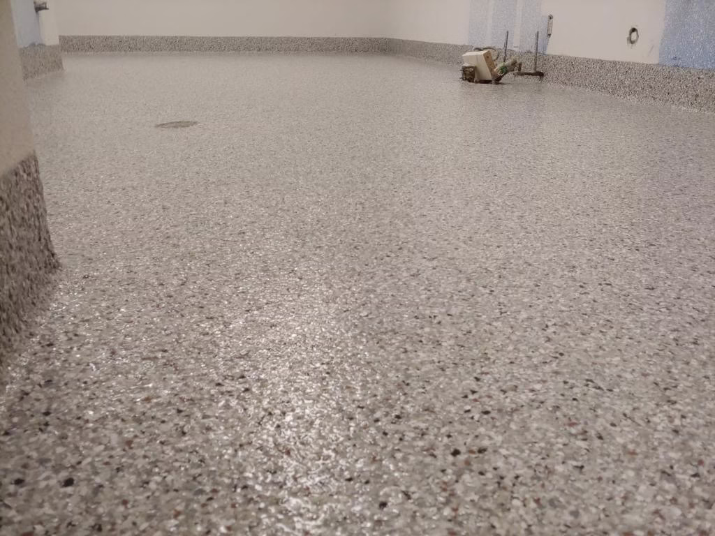 Epoxy flake garage flooring installation in Windsor, Colorado by Hugo's Concrete, featuring decorative chip broadcast system with durable finish