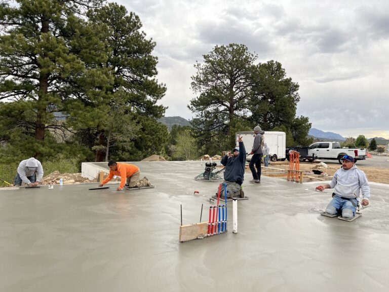 Concrete contractor installing a new concrete slab at a residential site, showcasing skilled workmanship and quality materials.