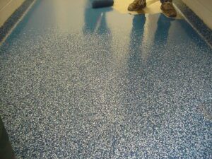 Epoxy flooring with flake finish installed in a Loveland auto repair shop by Hugo’s Concrete, built for durability and easy cleaning