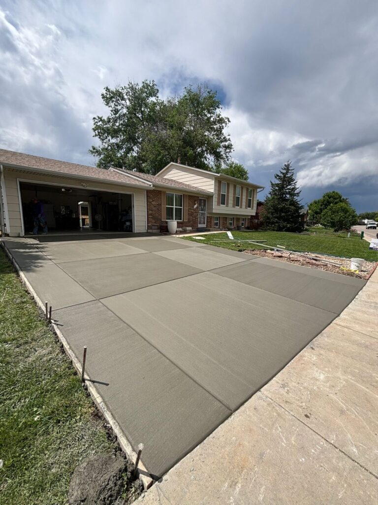 New broom-finished concrete driveway installed by Hugo’s Concrete on Hinsdale Drive in Fort Collins