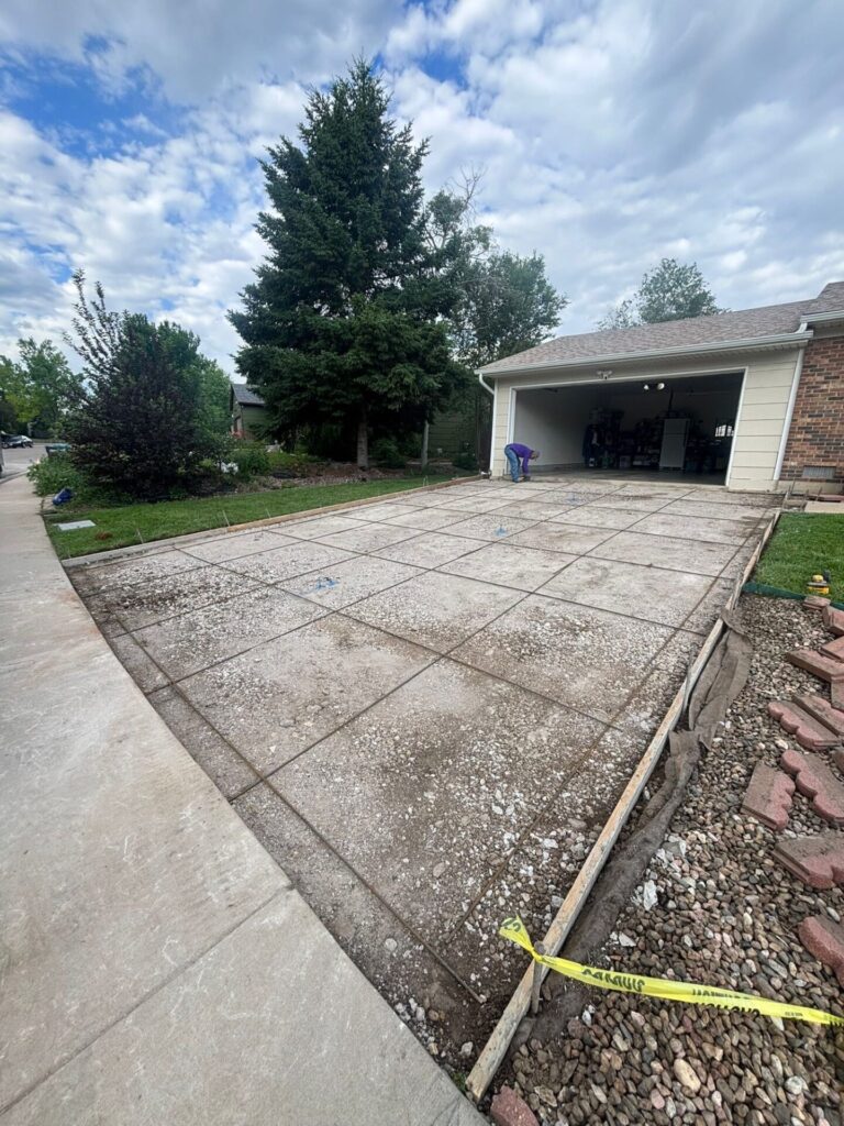 Old cracked concrete driveway in Fort Collins before replacement by Hugo’s Concrete on Hinsdale Drive