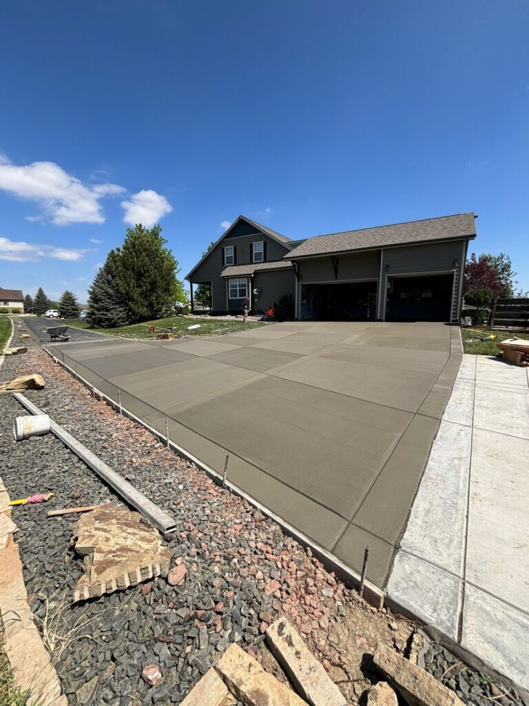 New broom-finished 4000 PSI concrete driveway installed in Berthoud, CO by Hugo’s Concrete