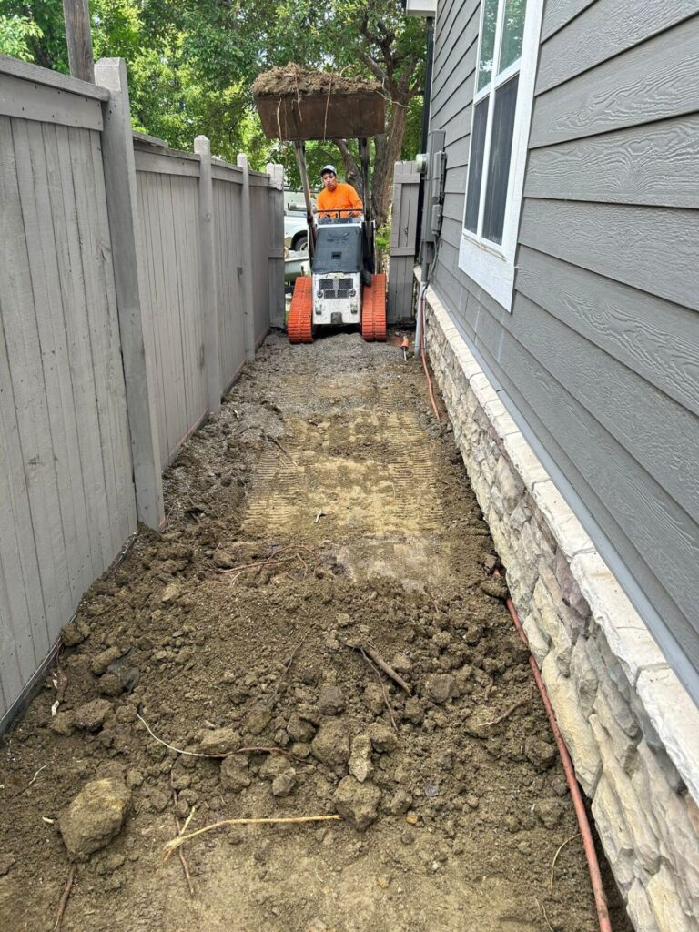 Excavated and compacted ground with rebar installed for new concrete sidewalk and walkway on Aruba Dr, Fort Collins, CO