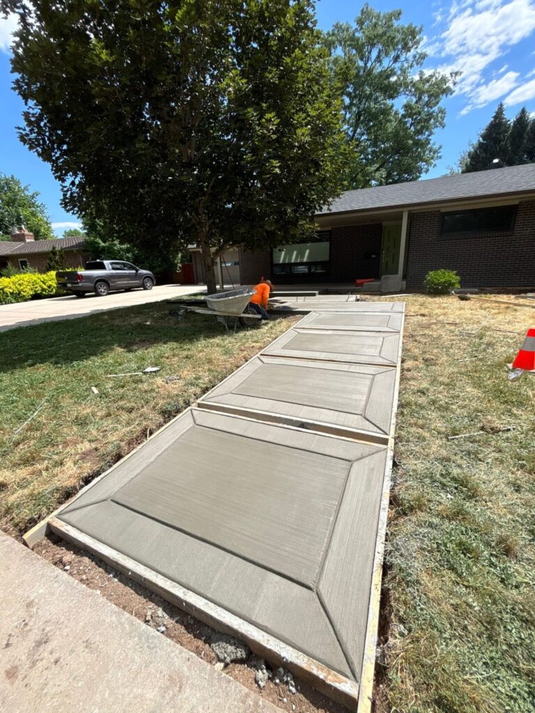 Freshly poured walkway with custom edge design in Fort Collins by Hugo's Concrete