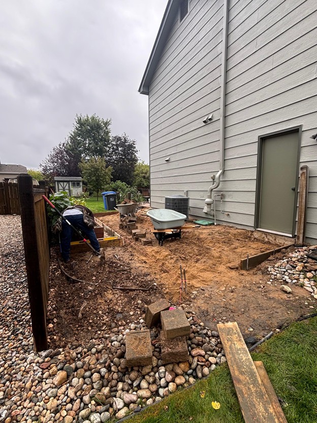 Preparing slope and AC pad before new concrete patio pour in Loveland CO