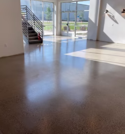 Spacious interior of a commercial property in Colorado featuring a polished concrete floor with a smooth, glossy finish, enhancing the modern aesthetic under natural light.
